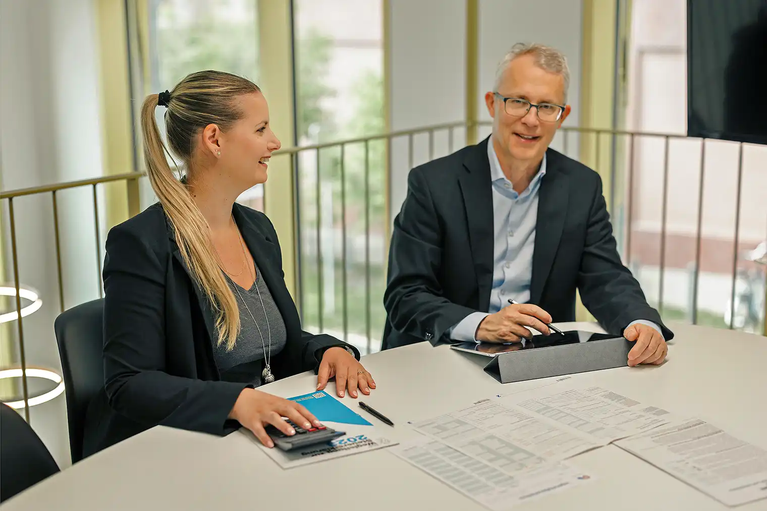 Das Foto zeigt Steueranwalt Rolf Benz und eine Mitarbeiterin bei der Arbeit. Der Bildlink führt auf die Seite Porträt.
